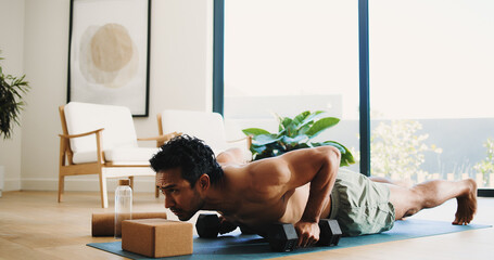 Fitness, man and push up in home with weights for balance exercise, strength training or...
