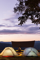 The landscape of illuminated camp tents during sunset.