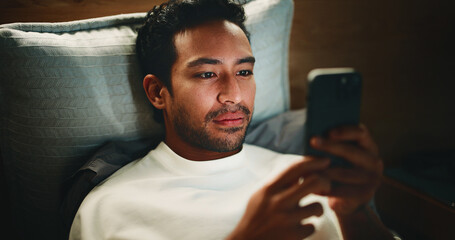 Night, man and browse in bed with phone for text message reply, social media or check dating app...