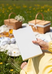 Woman Holding Hardcover Book Mockup, On-Model White Blank Book Cover Mock up , Woman Holding Blank White Book Mockup Picnic in Sunny Park Grass Field POV