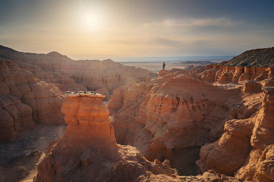 Small silhouette of photographer in desert landscape with rock formations canyon