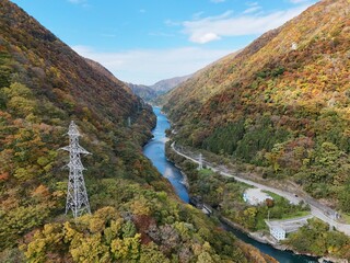 A beautiful mountain valley with a river running through it. The trees are full of leaves and the sky is clear