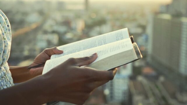 young black Woman afro american Reading Bible at Sunset Outdoors