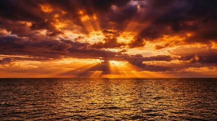 Dramatic Golden Sunset Over Ocean With Sun Rays and Clouds