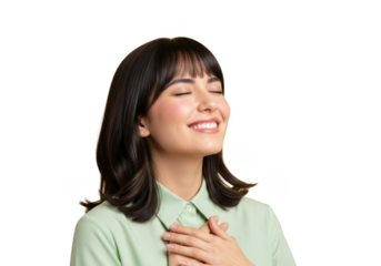 A young woman with her eyes closed and hands on her heart, expressing a sense of peace and contentment, with a soft smile on her face isolated on transparent background