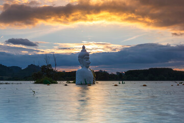 Golden Sunset of Submerged Buddha Statue in water (Phra Chom Nam) in Khao Rakham Reservoir at Trat Province of Thailand