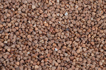 Buckwheat kernels display, Closeup of buckwheat grains storage, Detailed image of buckwheat groats in heap, Macro photograph showing bulk buckwheat kernels for packaging visuals
