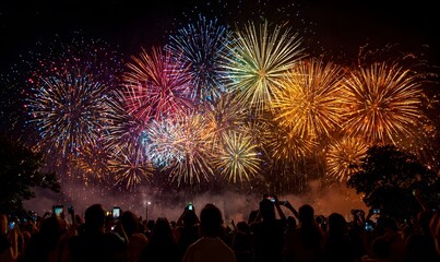 an enchanting display of fireworks illuminating the night sky, with people gathered in awe taking photos and capturing the vibrant colors on their phones