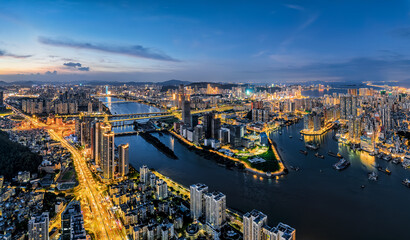 Fototapeta premium Vibrant modern city skyline with illuminated building and river at night in Zhuhai, China.