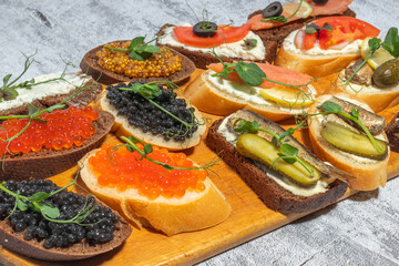 Variety of gourmet open-faced sandwiches with toppings on a wooden board