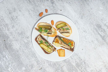 Top view of a plate with assorted canap&eacute;s and snacks on a rustic background.