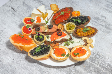 Assorted gourmet appetizers with caviar and cheese on a plate