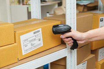 close up parcel box scanning process showing barcode verification during ecommerce shipping inspection step before delivery inside organized home warehouse environment