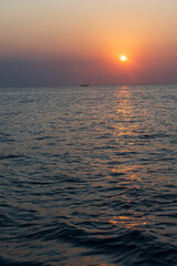 A breathtaking Zanzibar sunset paints the sky with golden hues as the sun dips below the horizon, casting a warm glow over the tranquil Indian Ocean. Nature's perfect farewell to another day in
