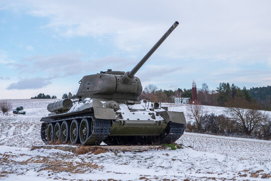 World War II Soviet T-34 tank monument in Death Valley near Kapi&scaron;ov&aacute;, Slovakia. Preserved armored vehicle in snowy open terrain with observation tower marking a historic battlefield.
