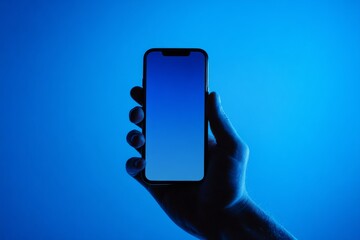 Hand holding smartphone mock up with blank screen against a blue gradient background, showcasing modern technology and design possibilities for digital content creation