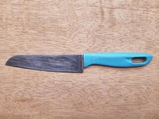 Used Stainless Steel Kitchen Knife on Wooden Cutting Board