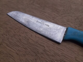 Scratched Stainless Steel Kitchen Knife on Wooden Background