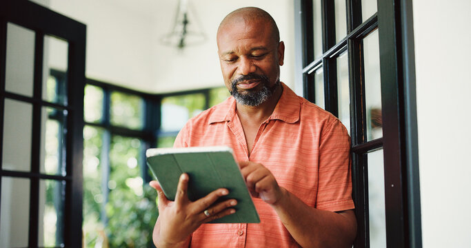 Typing, home and mature black man on tablet for internet, subscription and website for contact. House, communication and person on digital tech for networking, online email and connection for news