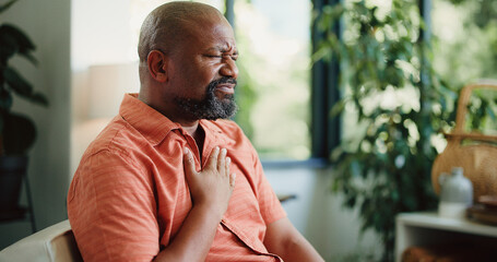 Upset, man and heartburn in home with chest pain from medical problem, inflammation or indigestion....