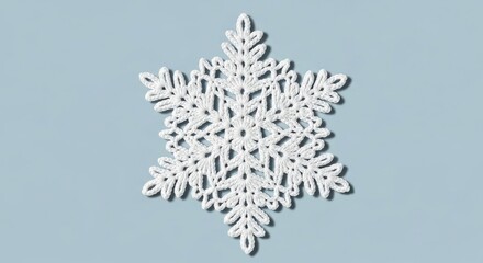 Intricate white crocheted snowflake on soft blue background