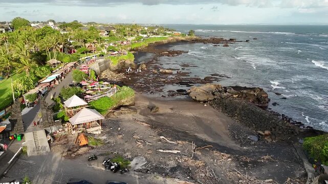 Bali cliff beach with a Hindu temple at Pantai Mengening beach/cliff side with Pura Gede Luhur Batu Ngaus temple located on the small peninsula off the cliffs from the main road. 