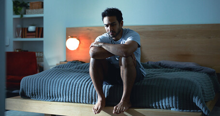 Night, lonely and man thinking with depression, mental health or insomnia from sad memories in...