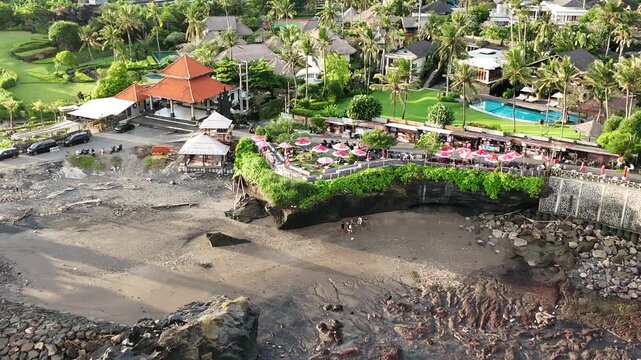 Bali cliff beach with a Hindu temple at Pantai Mengening beach/cliff side with Pura Gede Luhur Batu Ngaus temple located on the small peninsula off the cliffs from the main road. 
