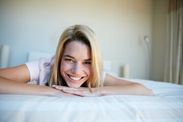 Fototapeta premium Happy, smile and portrait of woman on bed for resting, comfortable and wake up in morning. Bedroom, home and person with calm, chill and relax for lazy afternoon, wellness and peace on weekend