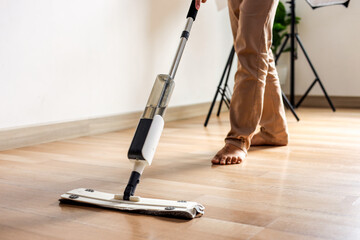 Fototapeta premium Barefoot Person Cleaning Wooden Floor with Modern Mop