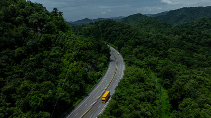 Aerial view semi truck trailer cargo on mountain curve road, Semi truck trailer cargo business logistic transportation on green forest road curve, Semi truck delivery asphalt road green forest tree.