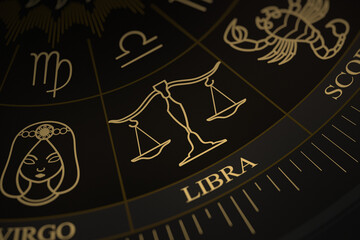 Detailed close-up of the Libra symbol on a gold and black astrology chart wheel featuring various zodiac constellations and symbols.