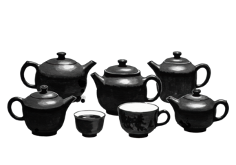 Sumi-e ink painting of traditional east asian tea vessels, teapot, and cups on a white background with copy space. Wabi-sabi minimalist aesthetic
