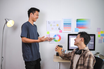Two Young Graphic Designers Happily Discussing Color Wheel and Creative Project