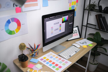 Designer's Desk With Computer Displaying Logo Concept Color Swatches