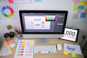 Modern Graphic Design Workspace With Computer Displaying Logo Concept