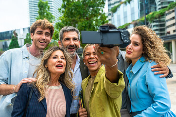 Diverse business professionals taking a group selfie in city