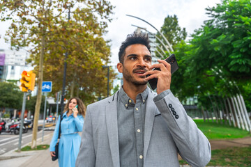 Businessman talking on phone while walking in city © unai