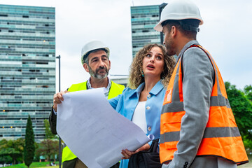Architects and engineers discussing urban development blueprints outdoors