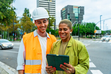 Architect and engineer colleagues discussing details on tablet in city