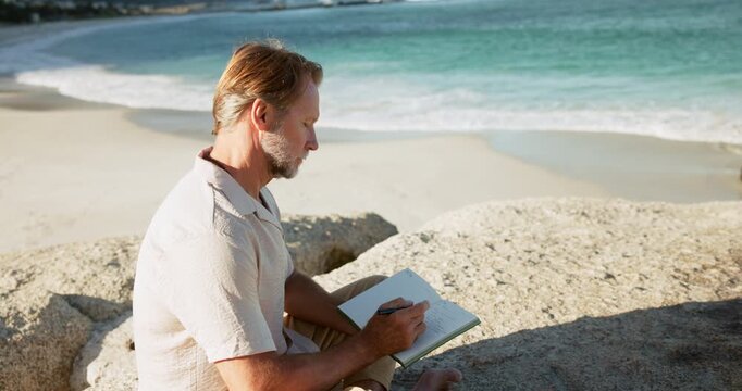 Beach, thinking or man writing in notebook for mental clarity, emotion reflection or awareness practice. Contemplating, reduce stress or person with gratitude journal for peace, thoughtful or outdoor