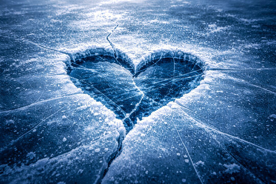 Horizontal frozen heart shape cracked in ice with cold blue tones, dramatic texture and emotional contrast symbolizing heartbreak, loss and emotional pain, powerful visual metaphor for relationships