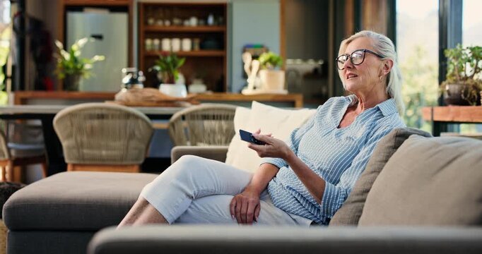 Watching tv, home and woman with remote on couch, entertainment or subscription for movie on website. Happy, mature person and change channel with controller, chilling and streaming film in lounge