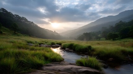 Misty mountain valley at sunrise with sunbeams breaking through clouds over a flowing stream