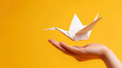 White origami crane floating over open hand