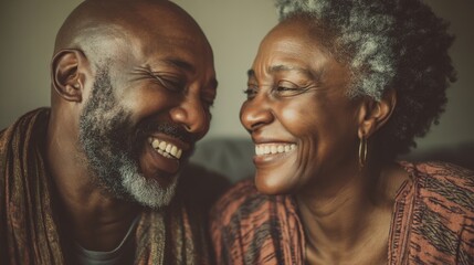 Two people sit close together smiling and laughing at each other in a cozy living room. They show joy while connecting and enjoying their time together.
