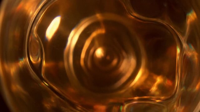 Golden Liquid in a Glass Container with Reflections and Refractions.
