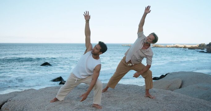 People, yoga and fitness at beach with stretching for wellness, holistic health and coordination. Active, friends outdoor and posture at ocean with extended side angle pose, balance and flexibility.
