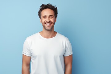 Fototapeta premium Cheerful man in a white t shirt broadly smiling, expressing happiness and joy