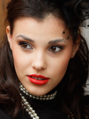 A woman with red lipstick and a black hat